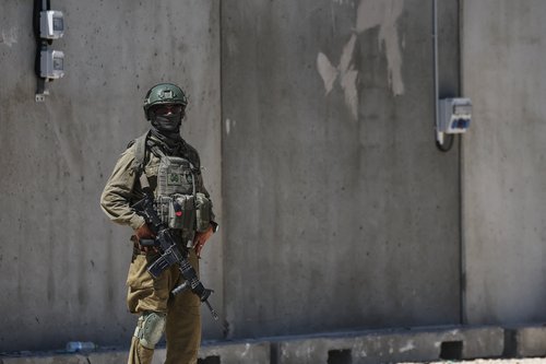 An Israeli soldier stands by during preparations for the opening of a new U.S.-backed Gaza Humanitarian Foundation (GHF) distribution center near the Al-Mawasi area of Khan Younis
