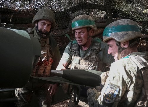 Artillerymen of the 152nd Separate Jaeger Brigade load a shell into an M114 self-propelled howitzer