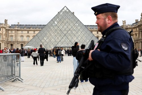 FILE PHOTO: A French CRS riot police officer patrols near the glass Pyramid of the Louvre Museum, after French police arrested suspects in the Louvre heist case, in Paris, France October 27, 2025. REUTERS/Abdul Saboor/File Photo