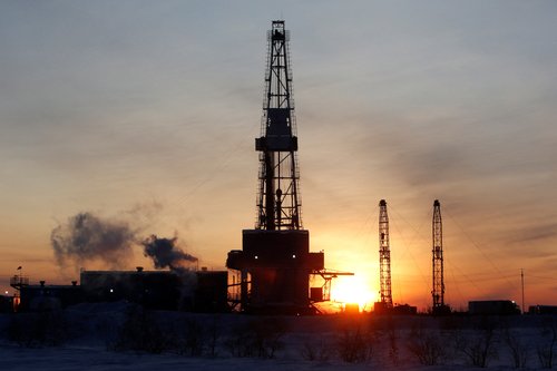 A general view shows an drilling rig at the Lukoil company owned Imilorskoye oil field, as the sun rises