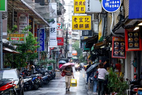 A person holds an umbrella while walking on a road, as Typhoon Fung-wong approaches in Taipei, Taiwan, November 11, 2025.