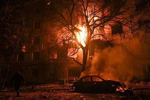 A resident walks in front of a burning apartment building which was damaged during an evening Russian drone strike, amid Russia's attack on Ukraine, in Zaporizhzhia, Ukraine November 25, 2025. REUTERS/Stringer