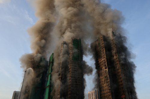 Smoke rises as flames engulf bamboo scaffolding across multiple buildings at Wang Fuk Court housing estate, in Tai Po, Hong Kong, China, November 26, 2025. REUTERS/Tyrone Siu TPX IMAGES OF THE DAY