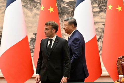 France’s President Emmanuel Macron (L) and China’s President Xi Jinping (R) walk.