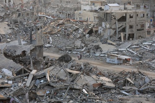 FILE PHOTO: Palestinian women walk among piles of rubble and damaged buildings, in Gaza City, November 24, 2025. REUTERS/Dawoud Abu Alkas/File Photo