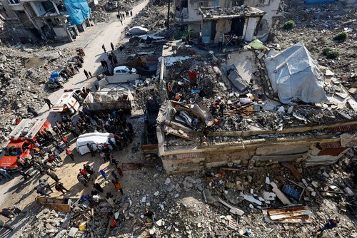 People gather during a search and rescue operation at the site of a house that was partially destroyed during the war and collapsed on Tuesday, at Shati refugee camp in Gaza City, TPX IMAGES OF THE DAY