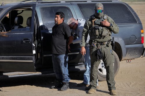 U.S. federal agents detain a man during an immigration raid in Thermal, California, U.S. December 19, 2025.