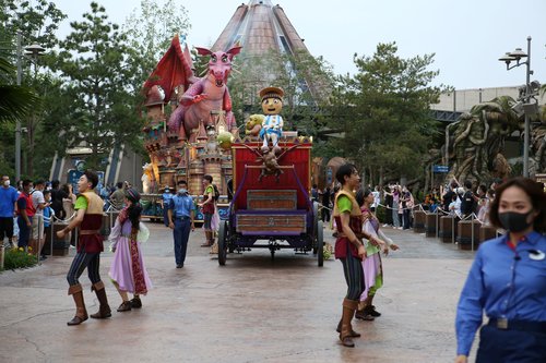 Visitors watch performers parade inside the Universal Studios Beijing during an internal pressure test