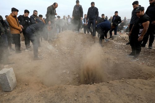 Relatives bury the body of an Iraqi Kurdish migrant, in Erbil