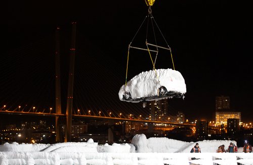 An ice-covered vehicle is unloaded from the cargo ship Sun Rio in the port of Vladivostok