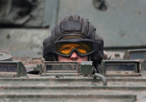 A service member of pro-Russian troops in a uniform without insignia drives an armoured vehicle in the Donetsk region