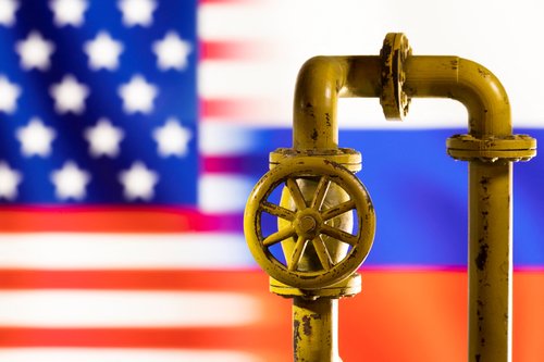 Illustration shows natural gas pipeline in front of word U.S. and Russia flag colours