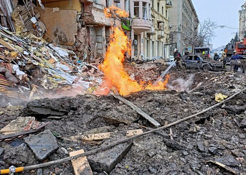 Rescuers work next to a building damaged by air strike in Kharkiv