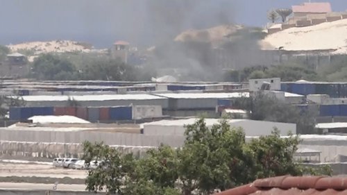 Smoke rises from behind buildings, in Mogadishu