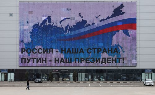 A man walks past an electronic screen in Moscow