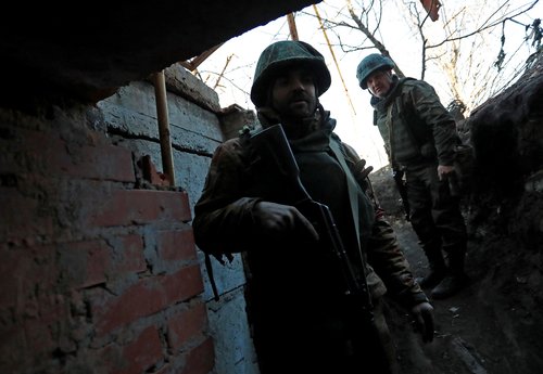 Service members of pro-Russian troops are seen outside a building, which according to the military, was previously a fighting position of Ukrainian armed forces in Marinka
