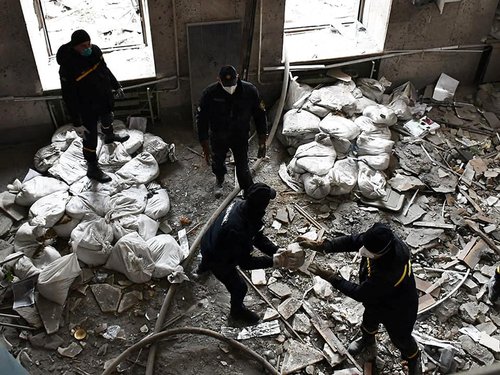 Rescuers work at a site of the regional administration building hit by cruise missiles in Mykolaiv