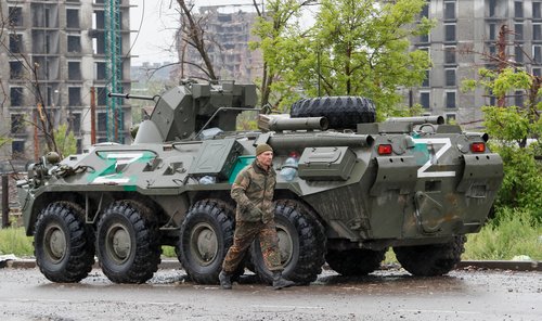 Service members of pro-Russian troops walk in Mariupol