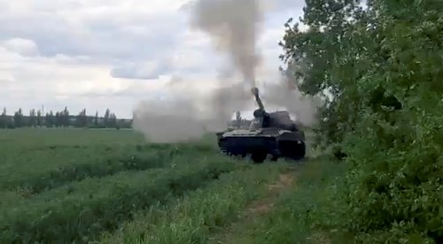 Ukrainian military members ride on a howitzer in location given as Donbas region