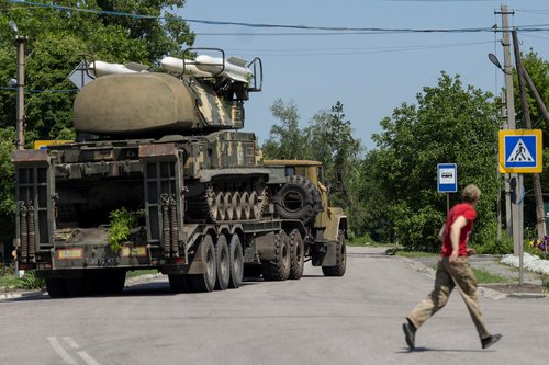 Resident looks at Ukrainian rocket launcher vehicle being transported near Kramatorsk, Donetsk