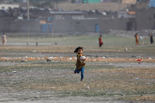 An Afghan girl carries a ball in Kabul