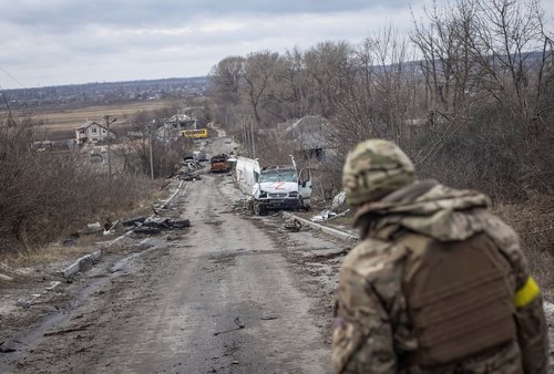 A Ukrainian serviceman looks at an empty street in the village of Torske