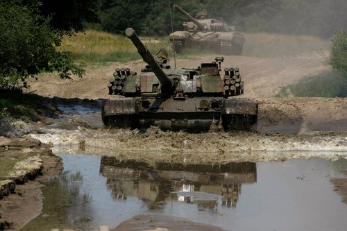 FILE PHOTO: The Polish tank PT-91, a newer model of the Soviet tank T-72, drives through water at the military base in Bedrusko near Poznan, western Poland