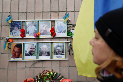 People visit graves of unidentified people, on a day of the first anniversary of Russia's attack on Ukraine, in Bucha