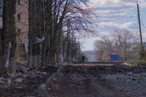 Local resident walks along damaged street in the town of Siversk