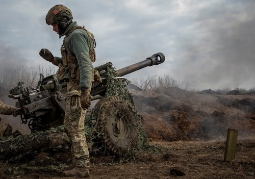 Ukrainian service members fire a howitzer M119 at a front line near Bakhmut