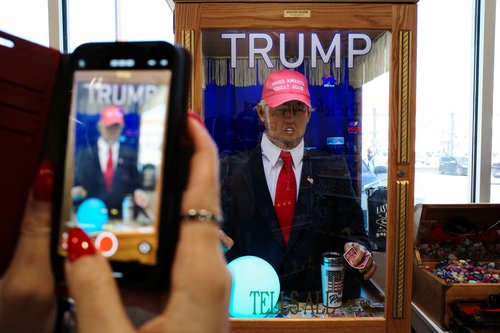A woman uses her iPhone to record a talking Donald Trump fortune teller machine inside the Arizona Last Stop Travel Center in White Hills