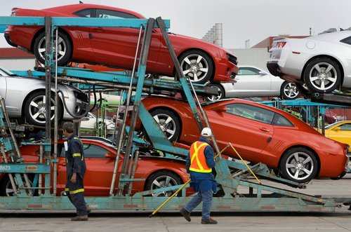 FILE PHOTO: General Motors auto workers load the new Chevrolet Camaro for delivery, at the company's Oshawa Ontario facility