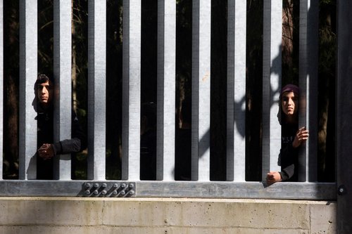 FILE PHOTO: Migrants stand near the wall on Polish Belarusian border near Bialowieza