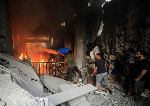 Palestinians work to rescue people at the site of an Israeli strike on a residential building in Gaza City