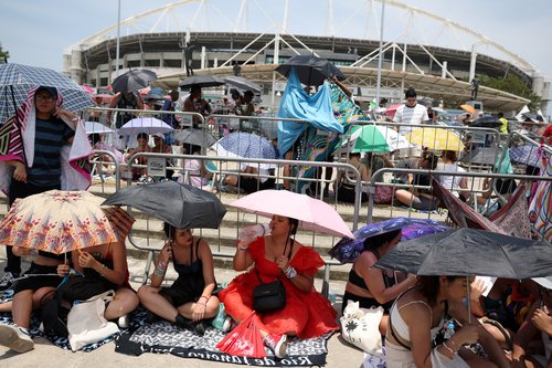 People holding umbrellas wait for the Taylor Swift concert, in Rio de Janeiro