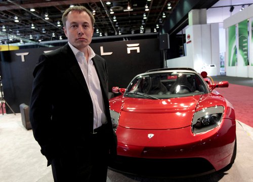FILE PHOTO: Tesla Motors Inc. CEO and Chairman Elon Musk stands in front of the Tesla Roadster electric vehicle as he addresses the media during press days of the North American International Auto Show in Detroit