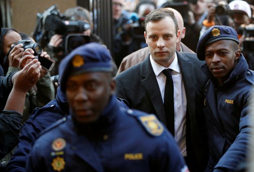 FILE PHOTO: Olympic and Paralympic track star Oscar Pistorius is escorted by police officers as he arrives for his sententencing for the 2013 murder of his girlfriend Reeva Steenkamp, at North Gauteng High Court in Pretoria