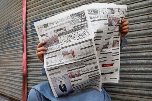 A man reads a newspaper after the Pakistani foreign ministry said the country conducted strikes targeting separatist militants inside Iran, in Karachi