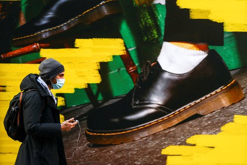 FILE PHOTO: A person walks past the window of a "Dr Martens" shoe shop amid the coronavirus disease (COVID-19) outbreak in central Madrid