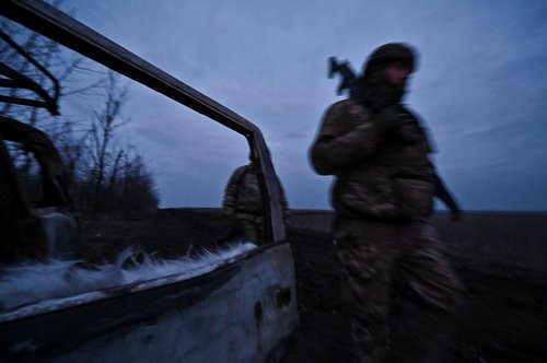 Ukrainian servicemen walk past a destroyed vehicle near the front line village of Robotyne in Zaporizhzhia region