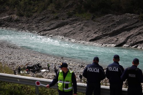 Police officers inspect the scene of a deadly car crash, near Kelcyre