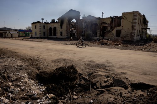 A person cycles past the train station that was damaged by repeated shelling in Kostiantynivka