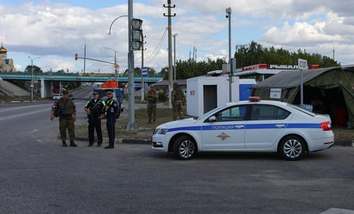 Russian law enforcement officers stand guard at a checkpoint in Belgorod