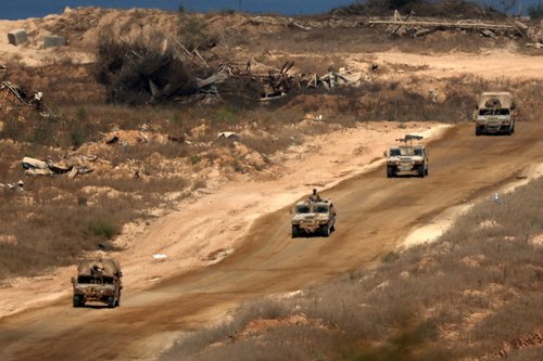 Israeli military vehicles manoeuvre, near the Israel-Gaza border, amid the Israel-Hamas conflict