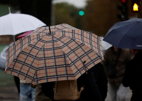 People walk through heavy rain in Vienna