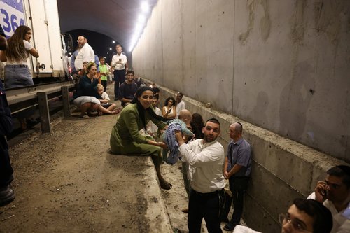 People take shelter during an air raid siren, in central Israel