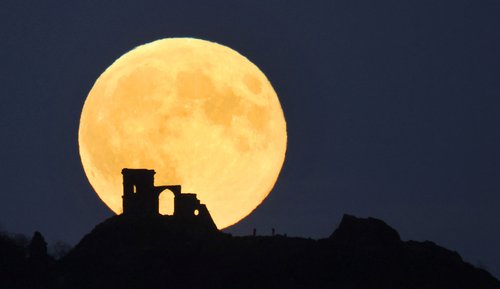 supermjesec, mjesec, People watch as the Supermoon, known as the Hunter's moon rises over Mow Cop castle in Mow Cop