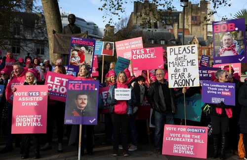 Protestors gather as British lawmakers debate the assisted dying law, in London