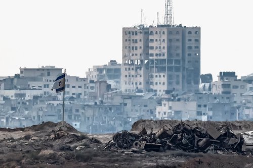 A damaged Israeli flag stands in Gaza, as seen from the Israeli side of the border between Israel and Gaza, August 7, 2025. REUTERS/Amir Cohen TPX IMAGES OF THE DAY