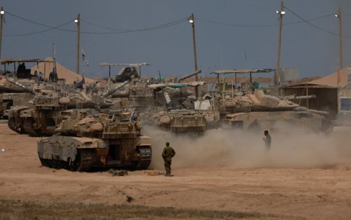 A view shows military vehicles on the Israeli side of the border with Gaza, as seen from Israel, August 12, 2025.